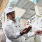 Direktur Utama Perum BULOG, Ahmad Rizal Ramdhani sedang mengecekkualitas beras. (dok. rentak.id)